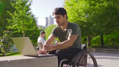 Junge-Körperlich-Behinderte-Menschen,-Die-Draußen-Mit-Einem-Laptop-Arbeiten.